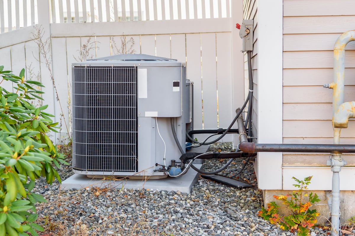 HVAC system external unit by a wooden fence in a house backyard, Bath, ME, USA